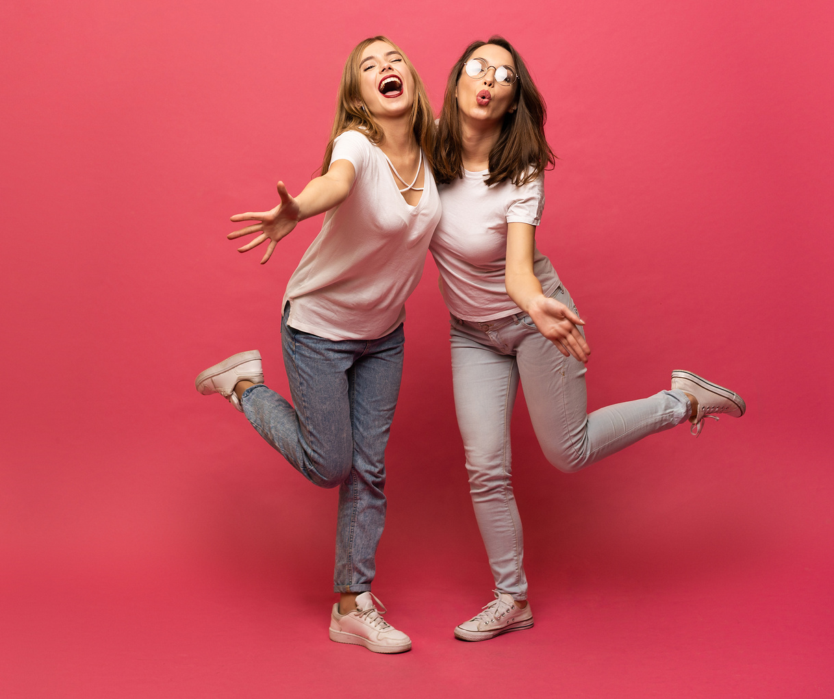 Two Exited Woman Having Fun and Raising Hands up. Standing on Pink Background. Lucky Mood.